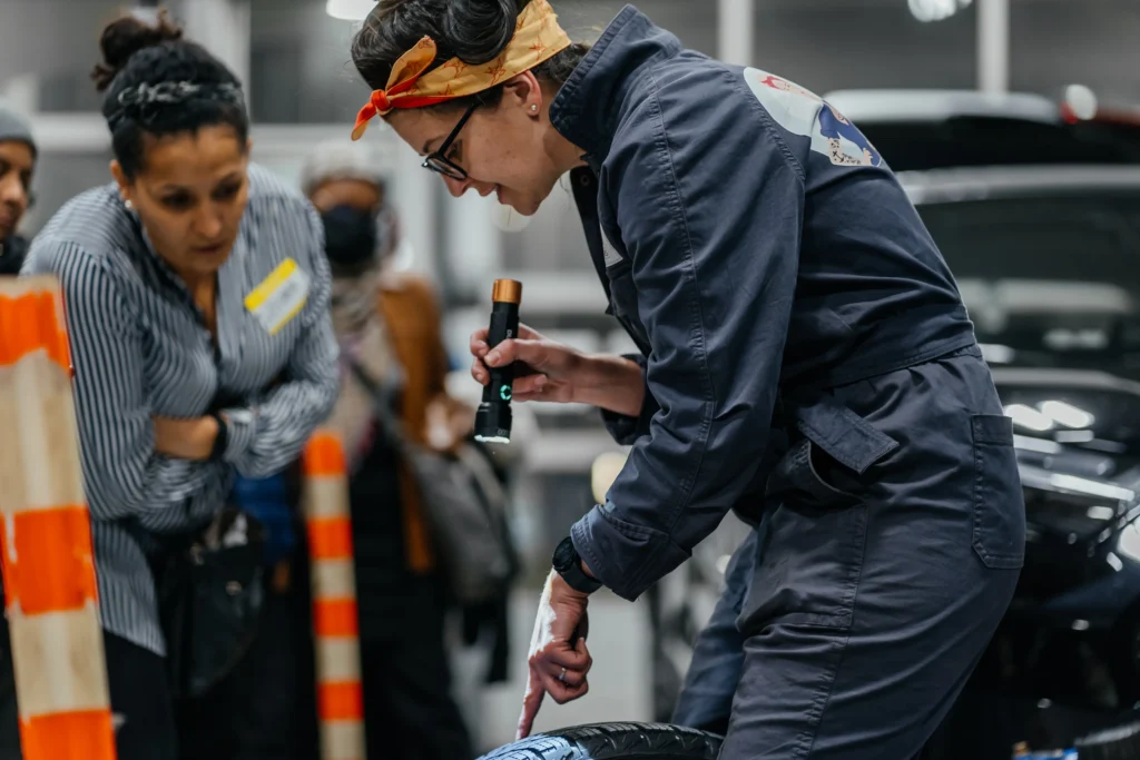 Photo of woman pointing a flashlight on a tire