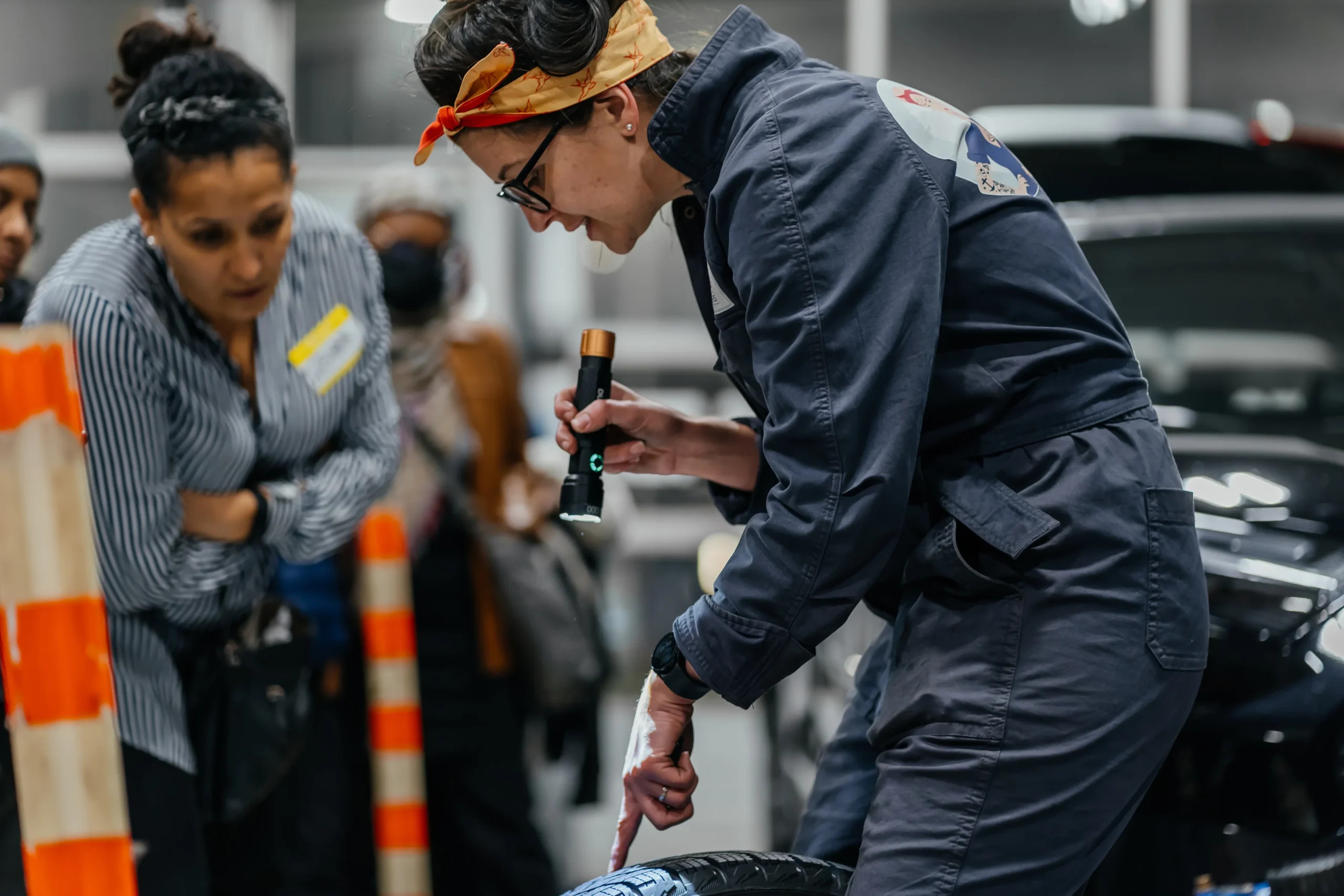 Photo of woman pointing a flashlight on a tire