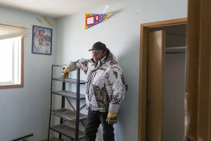 Clifford Anderson standing in the middle of his living room assessing the flood damage